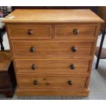 A modern pine chest of drawers, with three long an