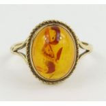 An unmarked single stone amber ring, finger size J