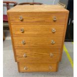 A light oak chest of five long drawers with facete