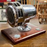 A presentation chrome cased siren mounted on woode