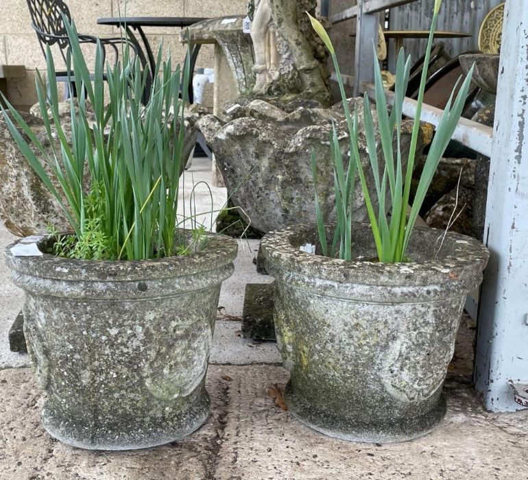 A pair of stone effect planters with moulded Tudor