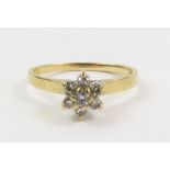 A small diamond cluster ring, marked '14k', finger
