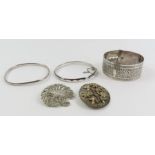 A silver hinged bangle, another bangle, a wide dec