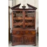 A 19th century mahogany bookcase having broken arc