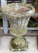 A stone effect urn shaped planter on square base,