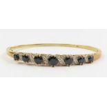 A sapphire and diamond set hinged bangle, marked '