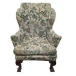 A 19th century wingback chair with front foliate c