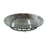 An oval glass coffee table with decorative openwor