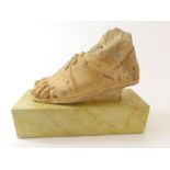 A stone carving of a foot with sandal, on modern s