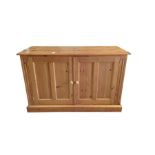 A pine side cabinet having pair of panelled doors