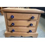 A small pine chest of three long drawers with dark