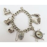 A silver bracelet with seven charms attached