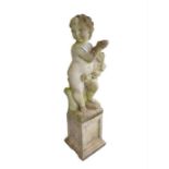 A garden figure of a cherub holding a garland of f