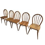 A set of five Ercol light wood stick back chairs