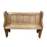 A late Victorian pine pew with bookrest to the bac