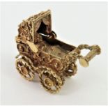 An unmarked charm or pendant of a pram with a baby