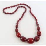 A graduated cherry amber bead necklace, the larges