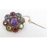 An unusual brooch, set with a central facetted amethyst