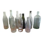 Nine old glass bottles including a dark green Mith