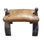 A camel saddle with embossed leather seat and wood