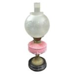 A Victorian oil lamp having moulded pink glass res