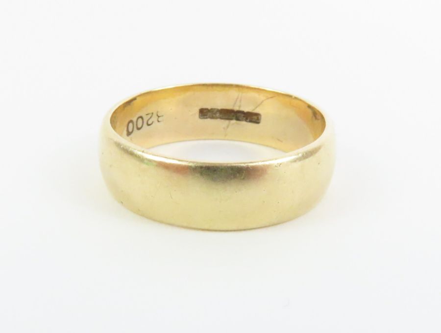 A wide 9ct gold wedding band, finger size Q centre