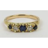 A carved head sapphire and diamond five stone ring