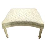 An upholstered rectangular stool with white painte