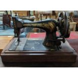 A Singer manual sewing machine in wood case