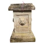 A square stone pedestal with lion mask decoration,