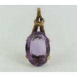 An unmarked amethyst set pendant, the oval facette