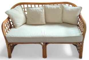 A bamboo framed two-seater sofa, with cream uphols