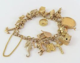 A 9ct gold fancy link bracelet, with various charm