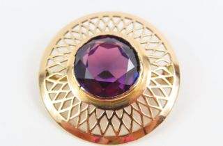 A brooch set with a synthetic colour change sapphi