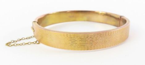 A 9ct gold hinged bangle, with half engine turned