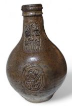 A late 17th century stoneware Bellarmine,the taper