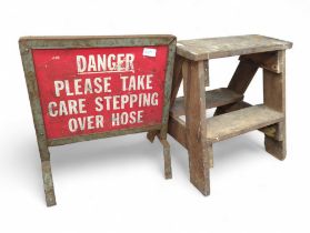 A vintage wooden stool and a metal Danger sign