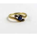 A twist set sapphire single stone ring, marked '18