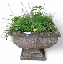 A reconstituted weathered footed garden urn, 45cm