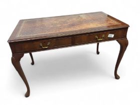 A mahogany writing table, with tooled leather top a