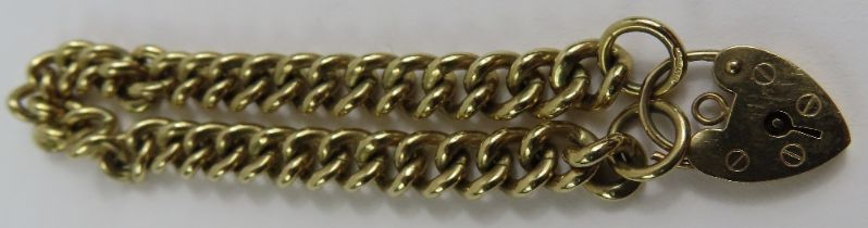 A 9ct gold heavy curb link bracelet, with heart pa