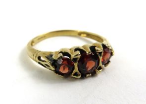 A 9ct gold garnet three stone ring, finger size Q,