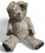 An early 20th century straw filled teddy bear