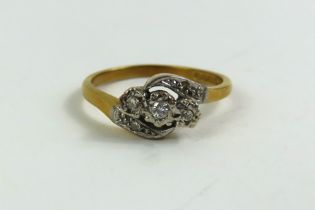 An 18ct gold three stone diamond twist ring with d