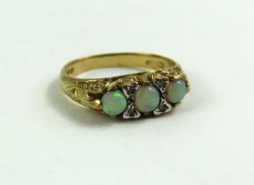 A 9ct gold opal three stone ring, with diamond poi