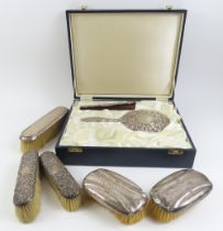 A silver backed handmirror and hair comb in fitted