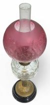 A Victorian oil lamp with etched cranberry glass s