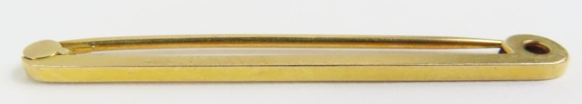 A plain bar brooch, marked '18ct', 3.9g gross