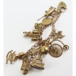 A 9ct gold charm bracelet with various charms atta