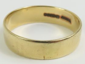 A plain 9ct gold wedding band, finger size T centr